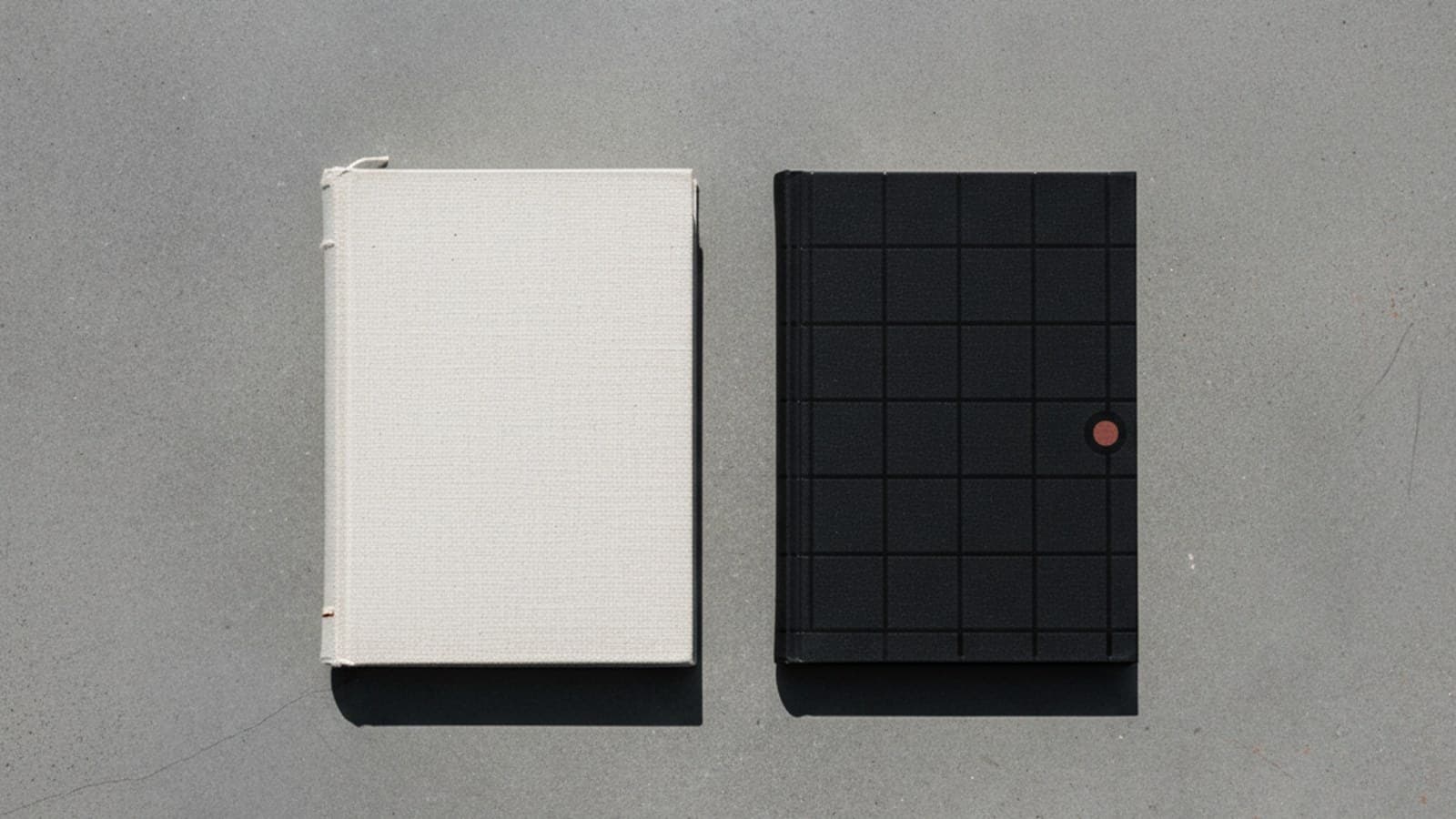 Comparativa visual entre brand book aspiracional grueso y manual de marca operativo delgado side by side sobre concreto editorial — fotografía Pentagram aesthetic